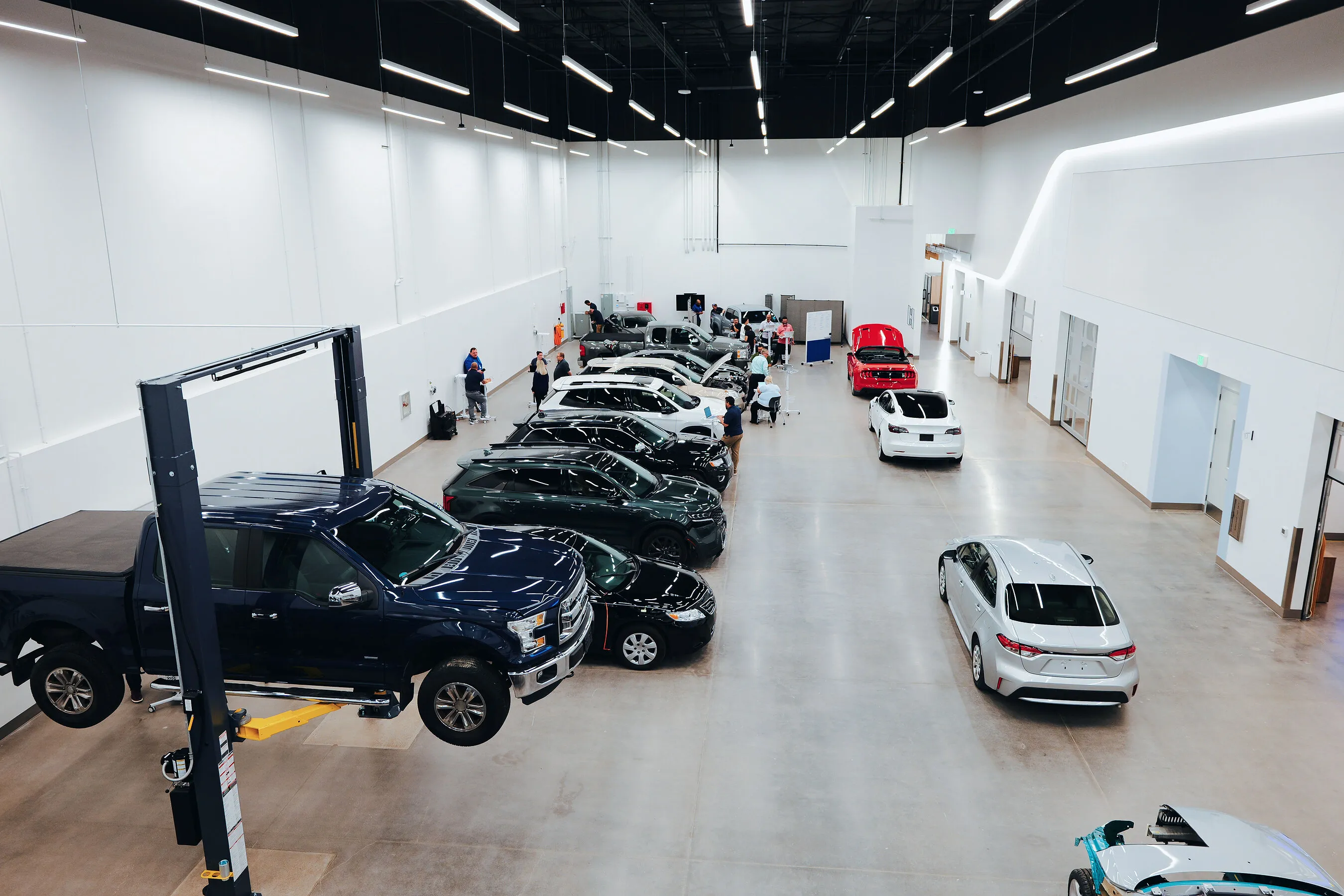 Cars being serviced in a bright automotive workshop.