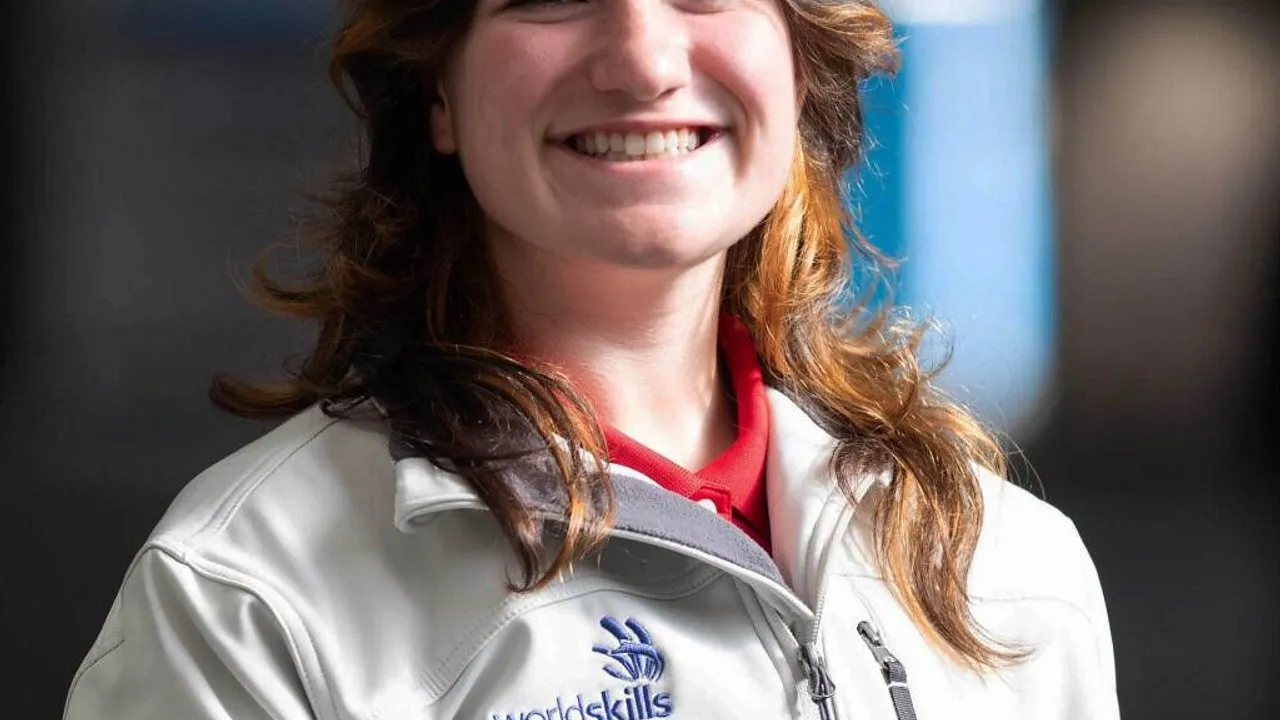 Elizabeth Brown wearing a white WorldSkills jacket and red shirt